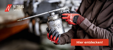 Handwerker trägt rote Nitras-Safety-Schutzhandschuhe und bedient eine Fettpresse in der Werkstatt